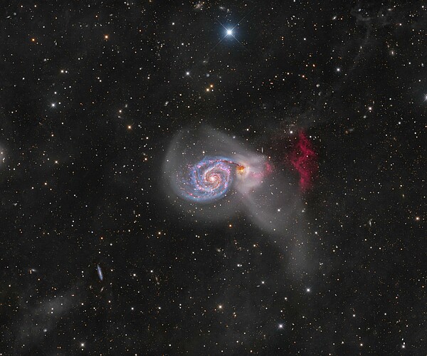 Die Galaxie Messier 51. Das Bild wurde erstellt durch das Kombinieren von 500+ Stunden an Daten, aufgenommen von Schweizer und anderen Astrofotografen des «Deep Sky Collective». Diese Aufnahme macht rotes Wasserstoffgas sichtbar, das aus der Galaxie herausströmt (rechts im Bild). Bild: 2023 Deep Sky Collective