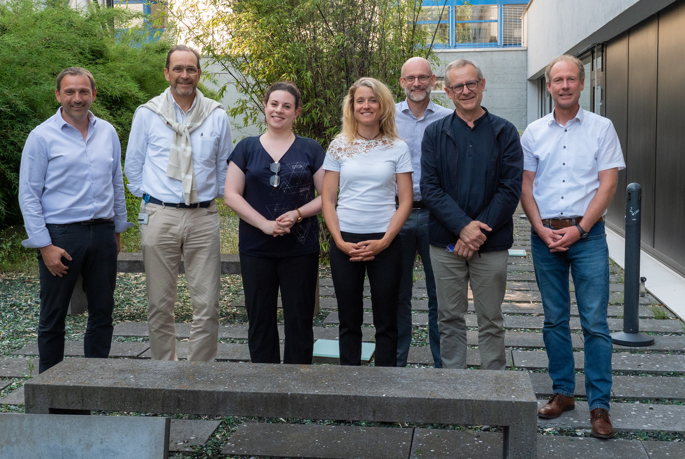 Des sourires après des négociations couronnées de succès: Frédéric Fragnière, secrétaire général de l’Hôpital du Valais (HVS), Pascal Strupler, président du Conseil d’administration de l’HVS, Aurore Barbry et Jeanne Picart, coprésidentes de l’ASMAVal, Pierre Turini, Direction de Centre, Eric Bonvin, directeur général de l’HVS, et Hugo Burgener, Direction de Centre (de g. à. d.). Photo: Hôpital du Valais.
